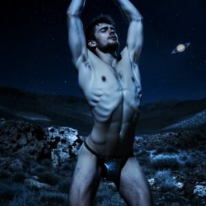 Man in a desolate landscape with the image of Saturn in the sky behind him